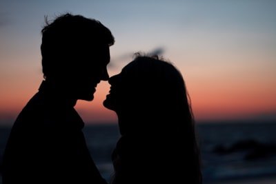 couple is kissing during sunset